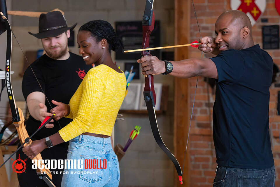 Students learning archery in school gymnasium